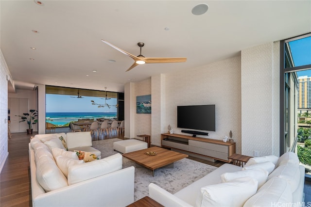 living room with ceiling fan, wood-type flooring, and a wall of windows