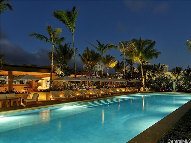 pool at night with a patio area