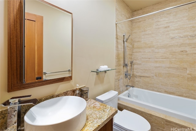 full bathroom with vanity, tiled shower / bath combo, and toilet