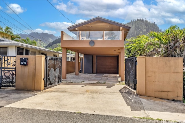 view of front of property featuring a mountain view, a garage, and a balcony