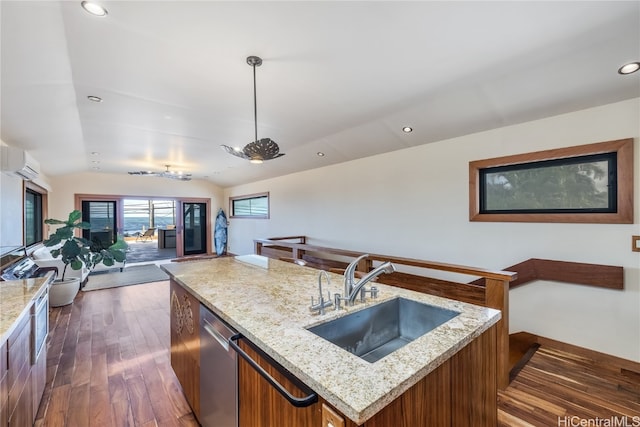 kitchen with lofted ceiling, dark hardwood / wood-style flooring, a kitchen island, an AC wall unit, and sink