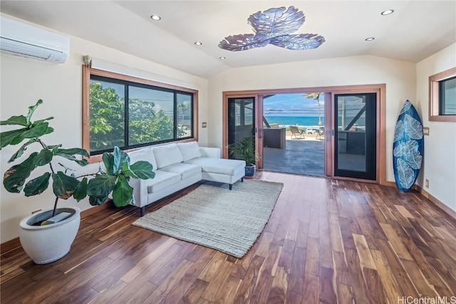 living room with dark wood-type flooring, lofted ceiling, and a wall unit AC