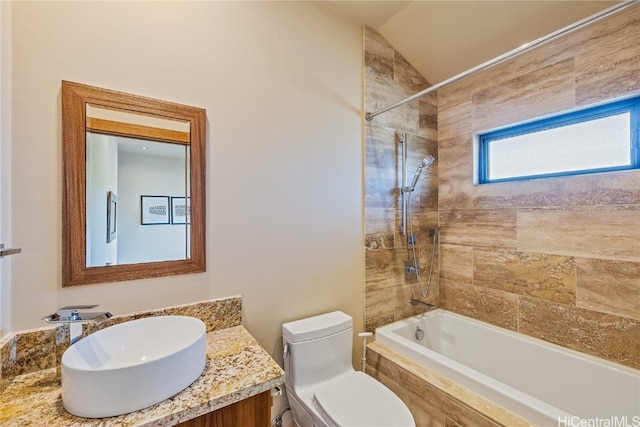 full bathroom with vanity, lofted ceiling, tiled shower / bath combo, and toilet