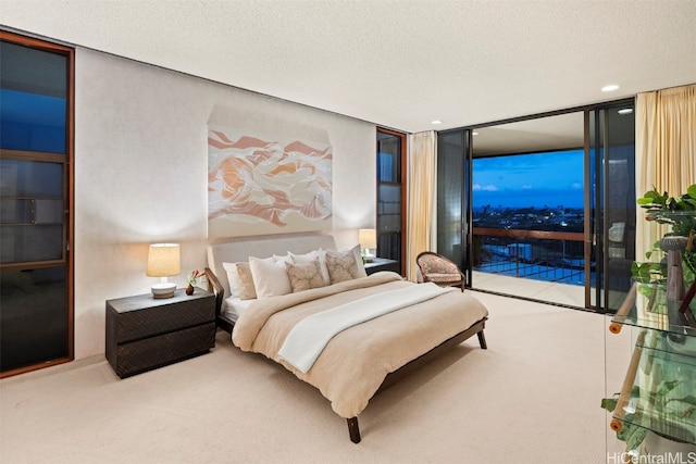 bedroom with access to outside, a textured ceiling, and expansive windows