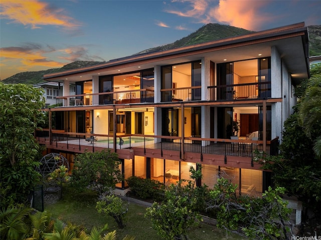 3869 Pokapahu Pl, Honolulu, HI 96816 - back of house at dusk featuring a balcony and a mountain view