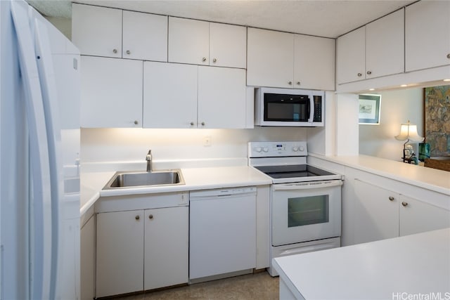 kitchen featuring white appliances, a textured ceiling, sink, and white cabinets