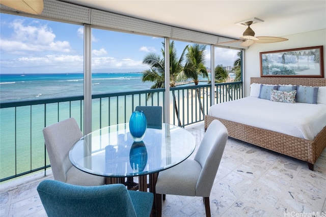 sunroom with a water view and ceiling fan