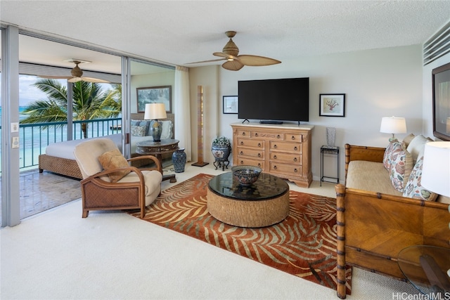 living room featuring ceiling fan, a textured ceiling, and carpet floors