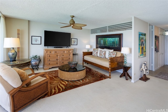 carpeted living room with ceiling fan and a textured ceiling