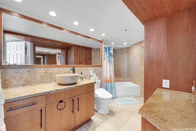 full bathroom featuring toilet, tile patterned flooring, shower / bath combination with curtain, vanity, and tile walls