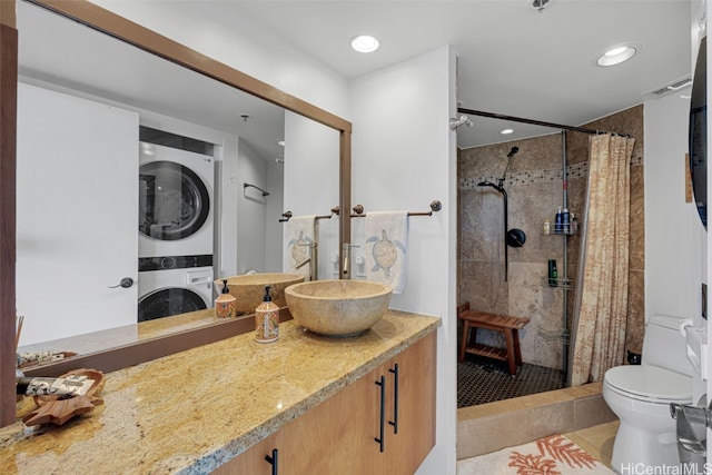 bathroom featuring vanity, stacked washing maching and dryer, a shower with curtain, and toilet