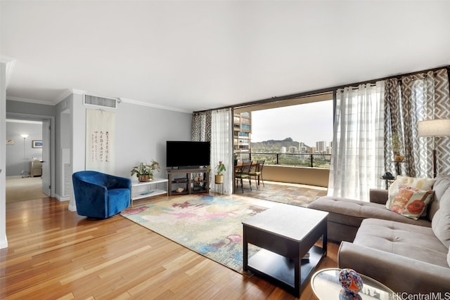 living room with ornamental molding and hardwood / wood-style floors