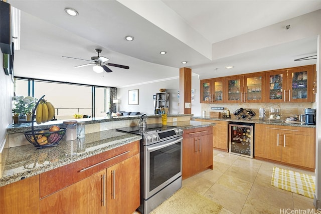 kitchen with light stone counters, stainless steel electric stove, ceiling fan, wine cooler, and light tile patterned floors