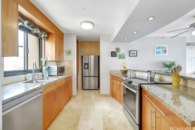 kitchen with light stone counters, stainless steel appliances, sink, and light tile patterned floors