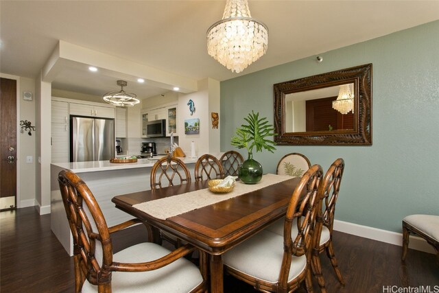 dining room with dark wood-type flooring and an inviting chandelier