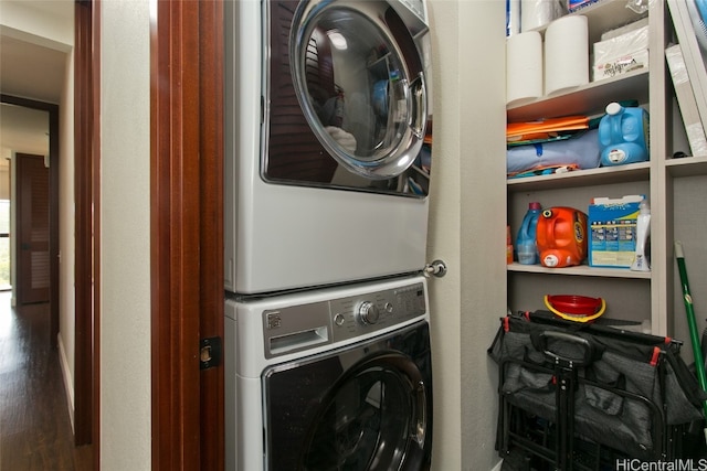 clothes washing area with stacked washing maching and dryer and dark hardwood / wood-style floors