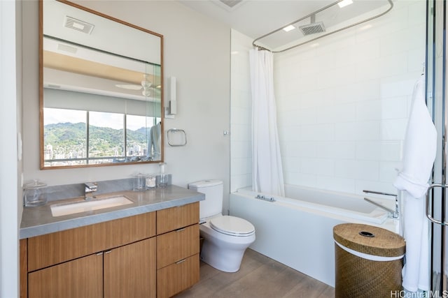 full bathroom with hardwood / wood-style floors, shower / bath combination with curtain, toilet, vanity, and a mountain view