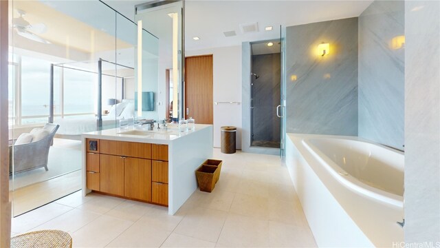 bathroom featuring vanity, independent shower and bath, and tile patterned floors