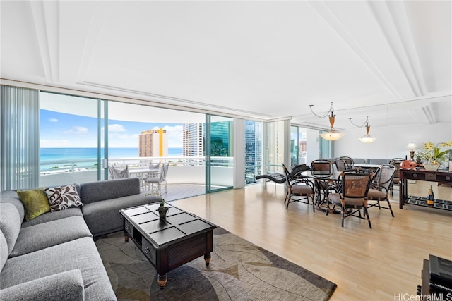 living room with a water view, wood-type flooring, beamed ceiling, and floor to ceiling windows