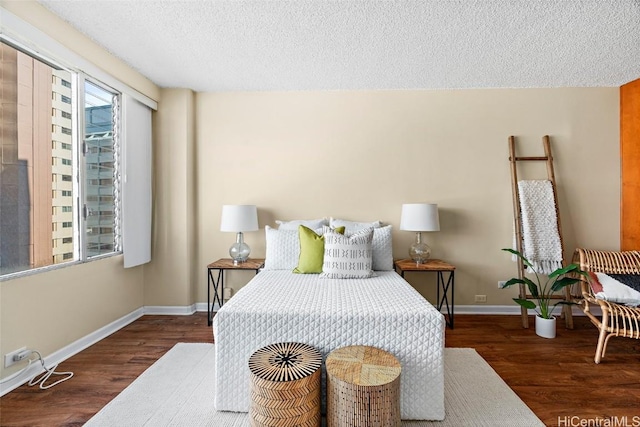 bedroom with dark hardwood / wood-style floors and a textured ceiling