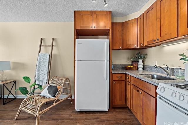 kitchen with white appliances, dark hardwood / wood-style floors, sink, and a textured ceiling