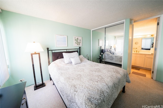 bedroom featuring connected bathroom, a textured ceiling, light colored carpet, and a closet