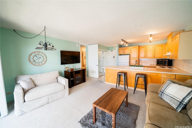 2140 Kuhio Ave Unit 1907, Honolulu, HI 96815 - living area featuring a textured ceiling, a chandelier, light carpet, and track lighting
