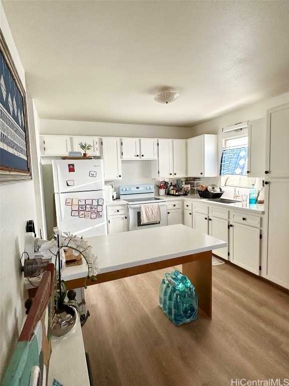 kitchen featuring white appliances, light hardwood / wood-style floors, sink, and white cabinets