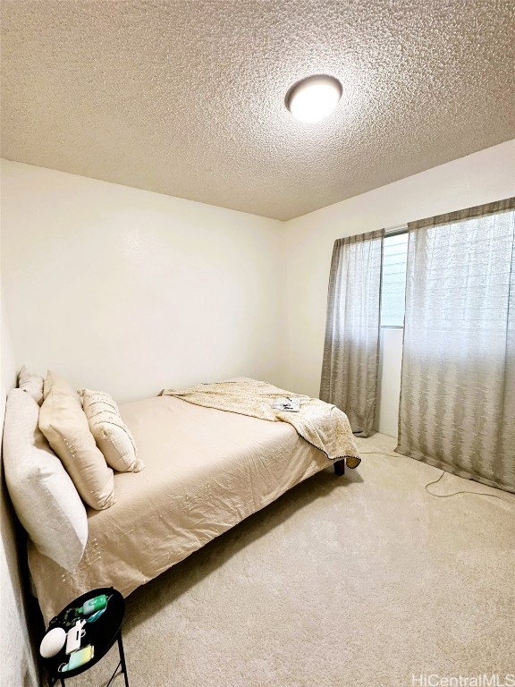 bedroom featuring carpet and a textured ceiling