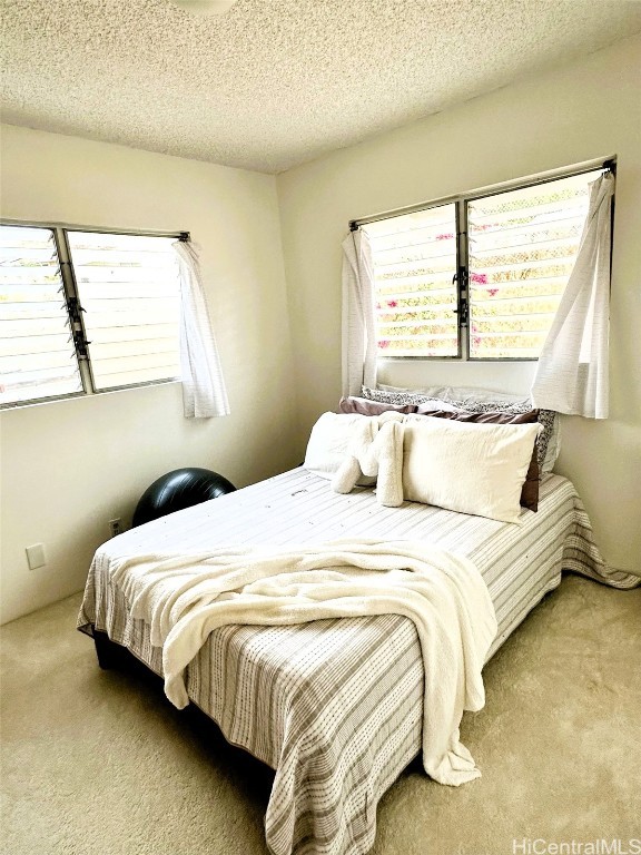 carpeted bedroom with a textured ceiling