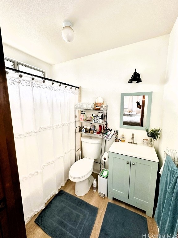 bathroom with vanity, hardwood / wood-style floors, toilet, and walk in shower