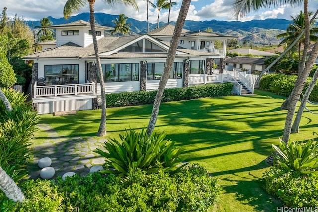 back of house featuring a lawn and a mountain view