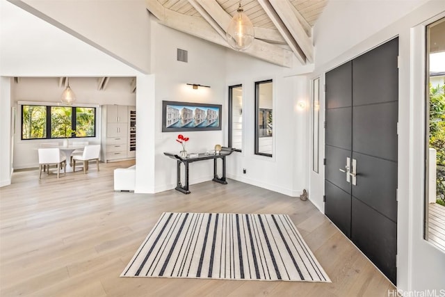 entrance foyer featuring light hardwood / wood-style flooring, beamed ceiling, wood ceiling, and high vaulted ceiling