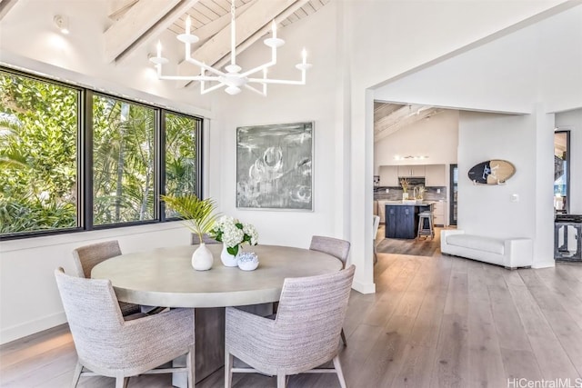 dining room with wooden ceiling, beamed ceiling, high vaulted ceiling, a notable chandelier, and light wood-type flooring