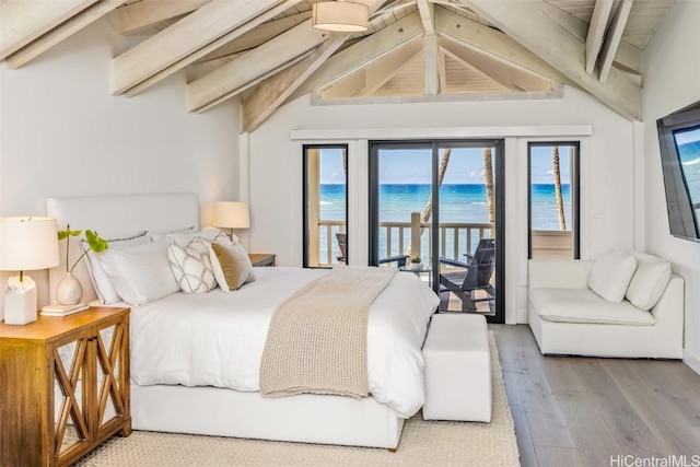 bedroom with hardwood / wood-style floors, lofted ceiling with beams, and access to outside