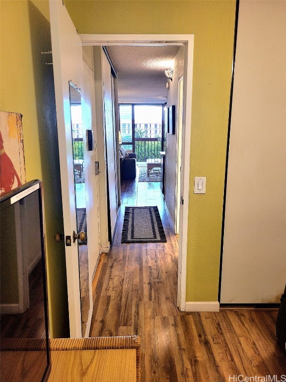 hallway featuring hardwood / wood-style floors and a textured ceiling