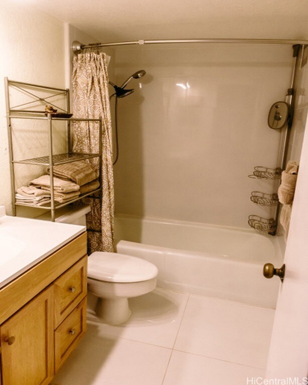 full bathroom with vanity, tile patterned flooring, toilet, and shower / tub combo