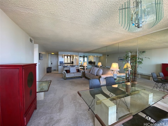 dining room with carpet, a textured ceiling, and an inviting chandelier