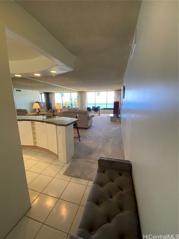 kitchen with white cabinetry, kitchen peninsula, and light tile patterned flooring