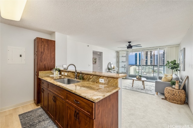 kitchen featuring light hardwood / wood-style flooring, a textured ceiling, electric panel, and sink