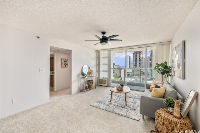 living room featuring a textured ceiling, carpet floors, and ceiling fan