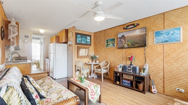 interior space featuring ceiling fan, a textured ceiling, light wood-type flooring, white fridge, and sink