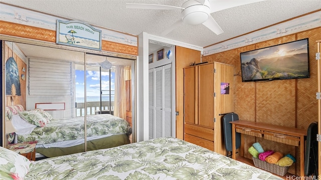 bedroom featuring ceiling fan, a textured ceiling, wood walls, a closet, and crown molding