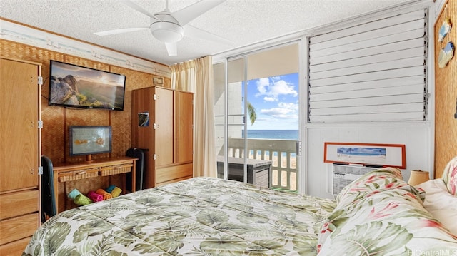 bedroom featuring wooden walls, a textured ceiling, access to outside, and ceiling fan