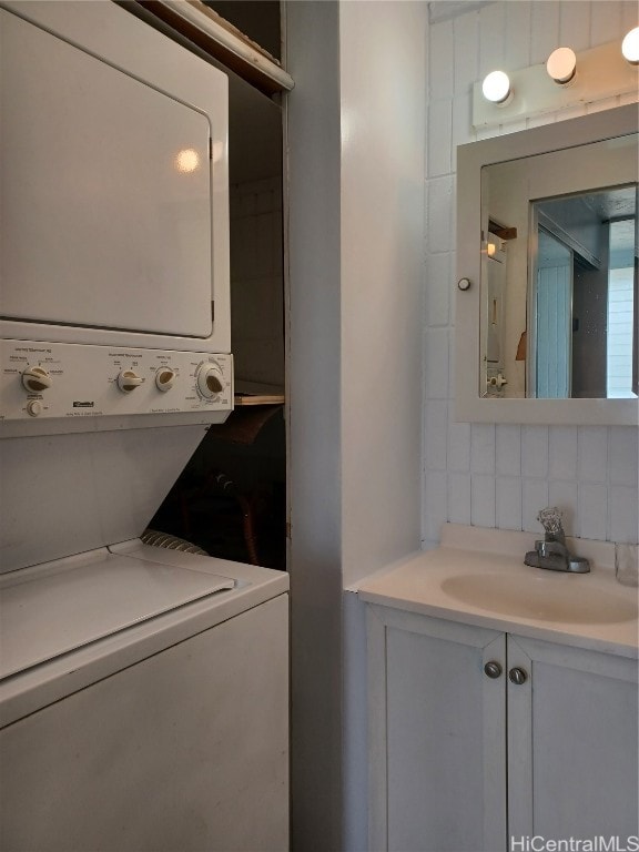 laundry area featuring sink and stacked washing maching and dryer