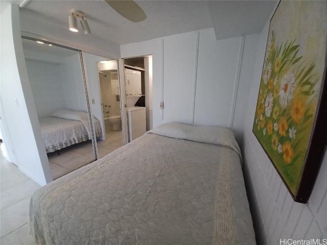 tiled bedroom featuring a closet, ceiling fan, and ensuite bath