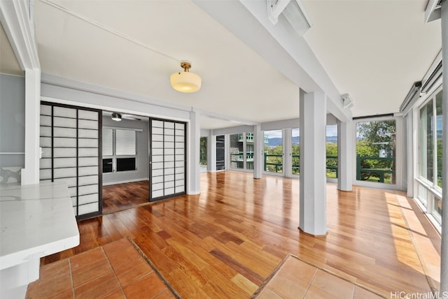 unfurnished sunroom featuring a wealth of natural light and ceiling fan