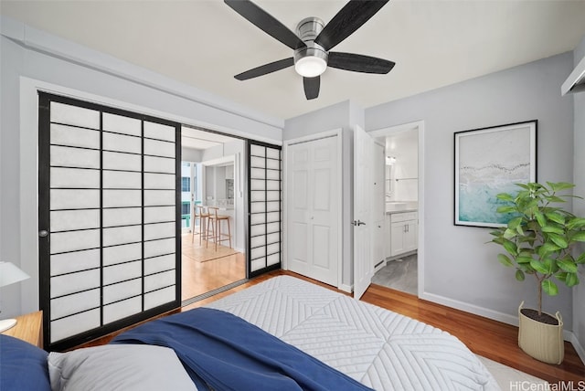 bedroom with connected bathroom, ceiling fan, a closet, and hardwood / wood-style floors