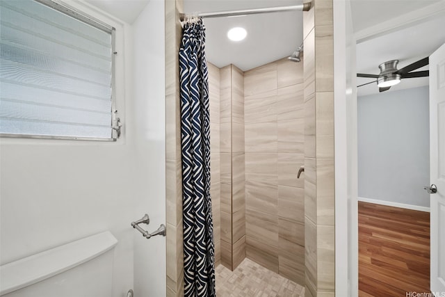 bathroom with a tile shower and ceiling fan