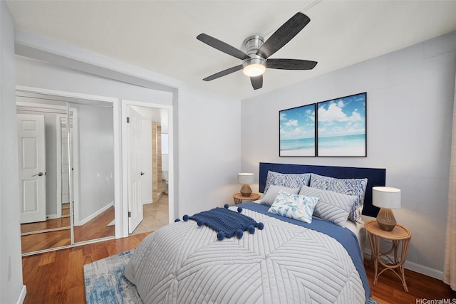 bedroom with ensuite bath, baseboards, a ceiling fan, and wood finished floors